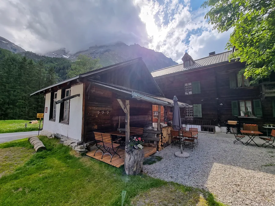 Rückseite mit gedecktem Sitzplatz, Gegenlicht und Wolken