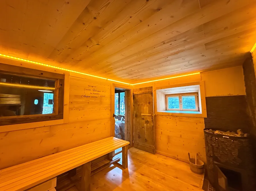 Vorraum der Sauna mit Holzbank und Lichtband