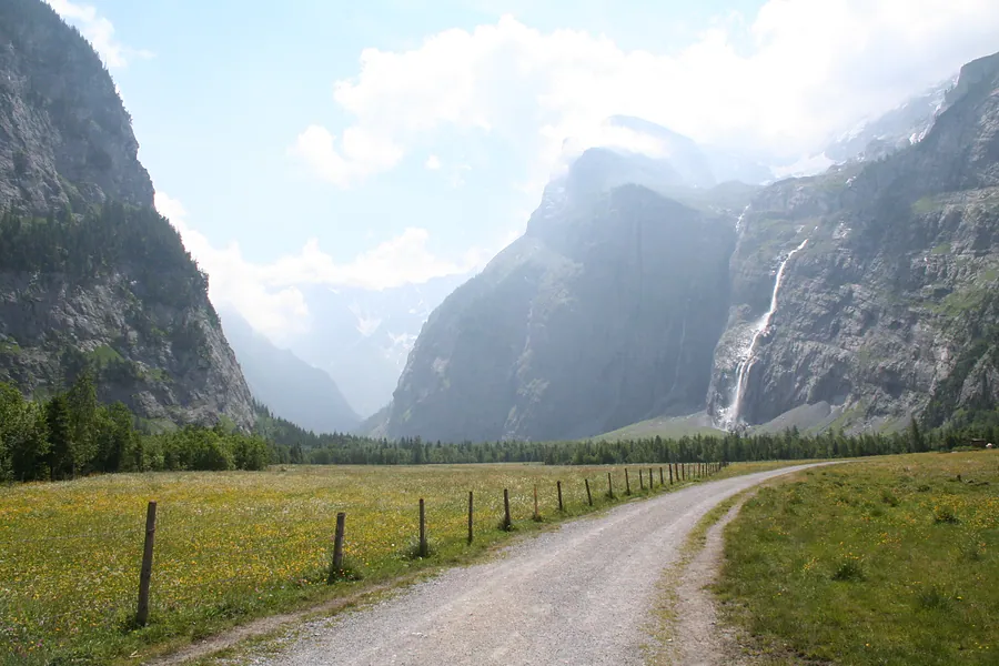 Die Naturstrasse zwischen den Wiesen im Talboden